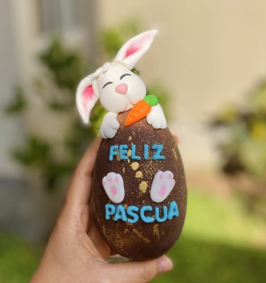 Delicioso huevo de chocolate en edición limitada con variedad de dulces y decoración temática.