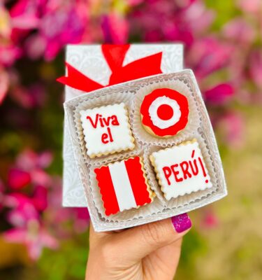 Cuatro alfajores decorados con fondant, presentados en una caja ecológica con opción de sticker personalizado.