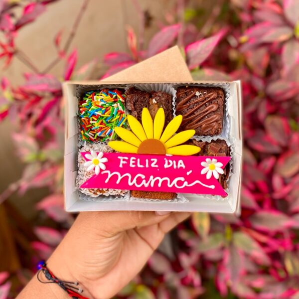 Cajita de 6 mini brownies con topper de fondant decorado con media flor y la frase “Feliz día, mamá”.
