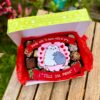 Caja surtida con brownies, trufas y alfajores variados, decorada con topper de fondant de una mamá gato abrazando a su bebé gato.