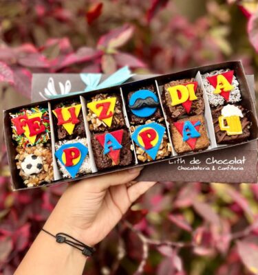 Caja estilo vintage que contiene brownies decorados en fondant con temática del Día del Padre, ideales para regalar.