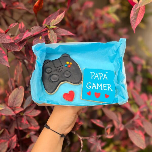 Dúo de galletas decoradas con temática gamer: una en forma de mando de PlayStation y otra con la frase “Papá Gamer”.