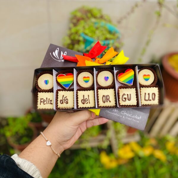 Caja vintage de 12 alfajores decorados con corazones en los colores de la bandera Pride y la frase “Feliz Día del Orgullo”.