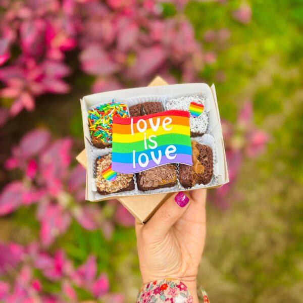 Caja con 6 brownies decorados con fondant en los colores de la bandera del Pride y la frase “Love is Love”.