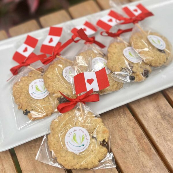 Galletas de avena empaquetadas individualmente, decoradas con una banderita del Perú en la parte superior, ideales para celebrar Fiestas Patrias.