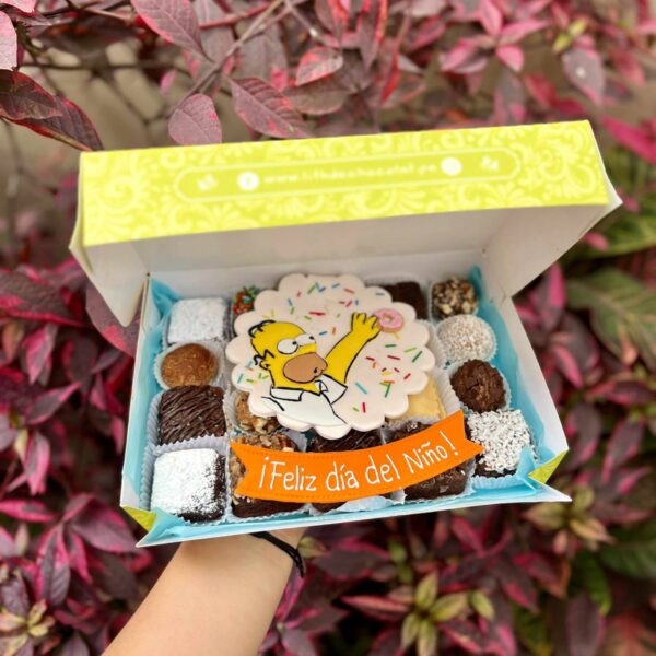 Mix Box con trufas, brownies y alfajores decorados con fondant de Homero Simpson y un banner que dice ‘Feliz Día del Niño’