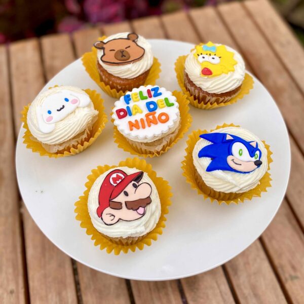 Caja de 6 cupcakes decorados en fondant con personajes: capibara, Sonic, Mario, Maggie Simpson, Cinnamoroll y uno con la frase “Feliz Día del Niño”