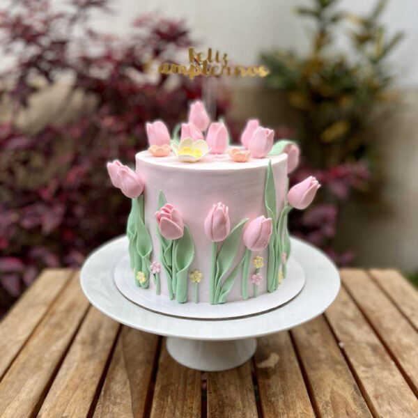 Torta de un piso cubierta en fondant blanco, decorada con elegantes flores 3D de azúcar en tonos delicados