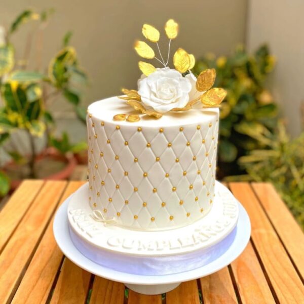 Torta de boda blanca de varios pisos, decorada con diseño capitoné que imita el efecto acolchado, con un acabado elegante y sofisticado.