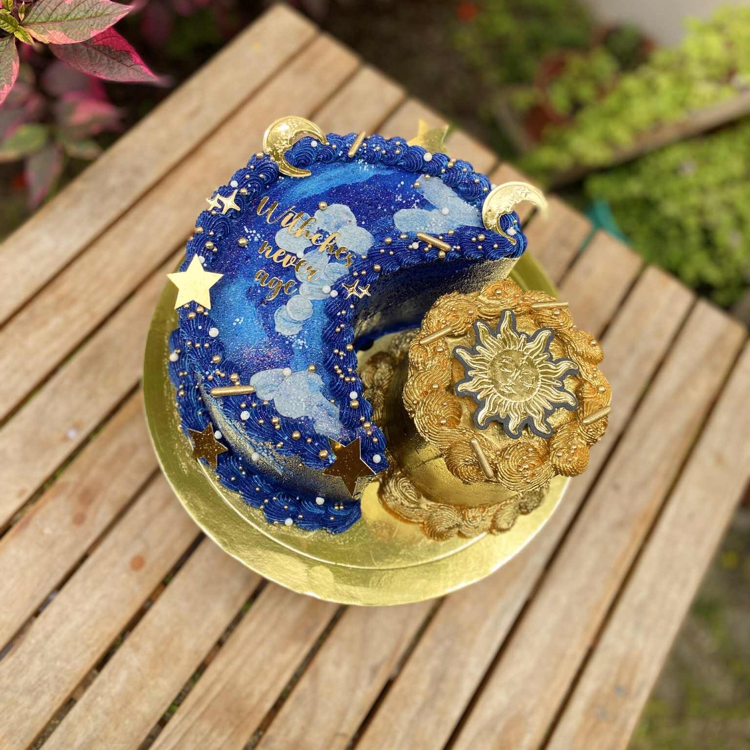 202bbccb-8437-4085-8f2d-c05a0c4c0aa4 Torta de media luna y sol, bañada en buttercream, con perlas comestibles, estrellas doradas y topper personalizado.