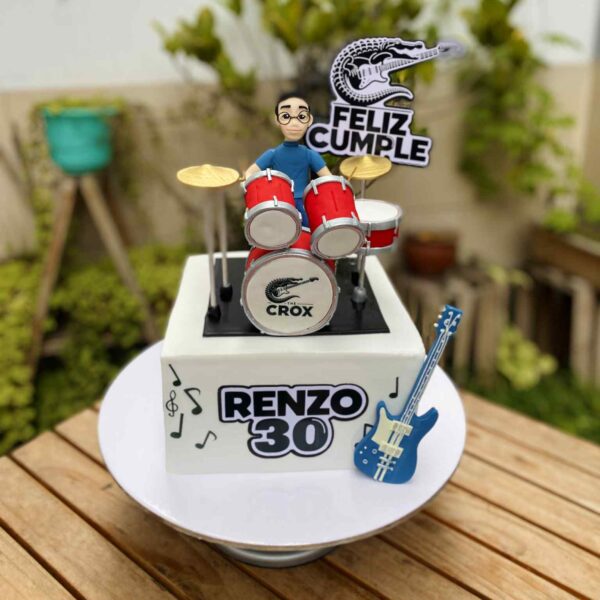 Torta de un piso decorada con un baterista en 3D de azúcar junto a su batería.