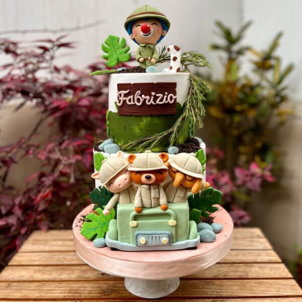 Torta de dos pisos temática plim plim safari, bañada en buttercream y decorada con figuras en fondant de animalitos y elementos de safari.