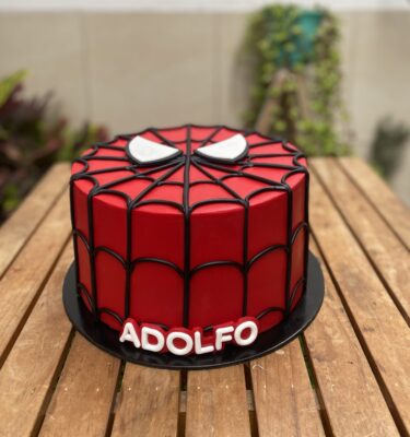 Torta forrada en fondant de Spiderman con líneas negras en fondant que simulan su traje y ojos de Spiderman en fondant al centro.