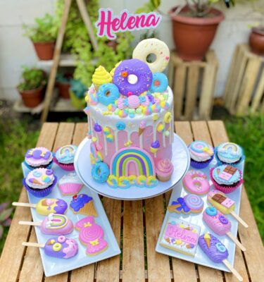 Torta dripcake decorada con donas, mini cupcakes, marshmallows y adornos de fondant como heladitos, mini donuts, paletitas de hielo y caramelos.
