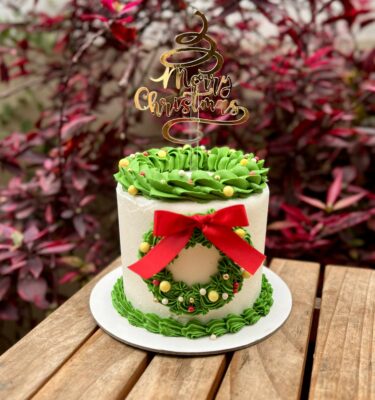 Torta decorada en buttercream con una corona navideña elaborada en buttercream.