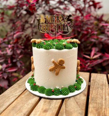 Torta decorada en buttercream con muñequitos de jengibre en fondant.