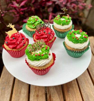 Pack de 6 cupcakes decorados en buttercream con toppers navideños de renos y la frase “Feliz Navidad”.