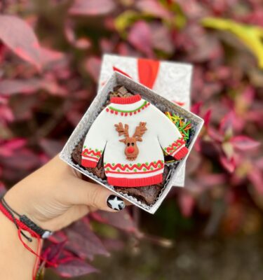 Mini four con 4 brownies decorados con un suéter navideño en fondant, perfectos para compartir o regalar en esta dulce temporada.