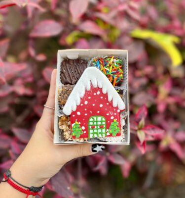 Mini six con 6 brownies decorados con una casita navideña en fondant, ideales para disfrutar o regalar en esta dulce temporada.