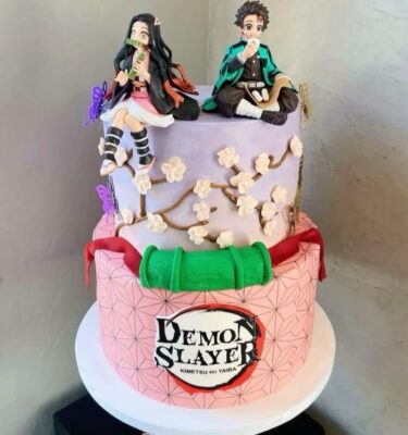Torta de dos pisos temática Demon Slayer con figuras 3D de Tanjiro y Nezuko elaboradas en fondant.
