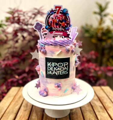 Torta bañada en buttercream, decorada con toppers de cartulina, papel de arroz y merenguitos.