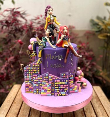 Torta temática K-Pop Demon Hunters forrada en fondant, con las tres integrantes de Huntrix modeladas en 3D de fondant.