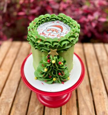 Burncake navideño bañado en buttercream con árbol decorado en buttercream, perlitas comestibles y estrella de fondant.