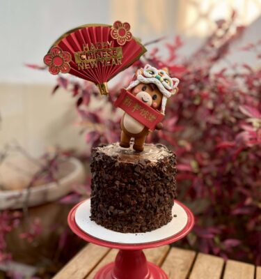 Mini torta de trocitos de chocolate con decoración en fondant 3D de caballito con gorro de dragón y topper “Happy Chinese New Year” por el Año Nuevo Chino 2026.