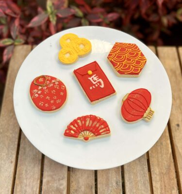 Pack de 6 galletas decoradas en glasé por el Año Nuevo Chino, con diseños de monedas chinas, traje tradicional, abanico, carta china y linterna.