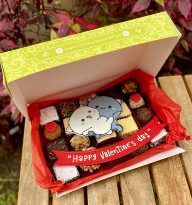 Mix Box de San Valentín con 20 postres variados entre trufas, alfajores y brownies, decorado con una pieza en fondant 2D de dos gatitos enamorados, presentado como un detalle dulce y romántico.
